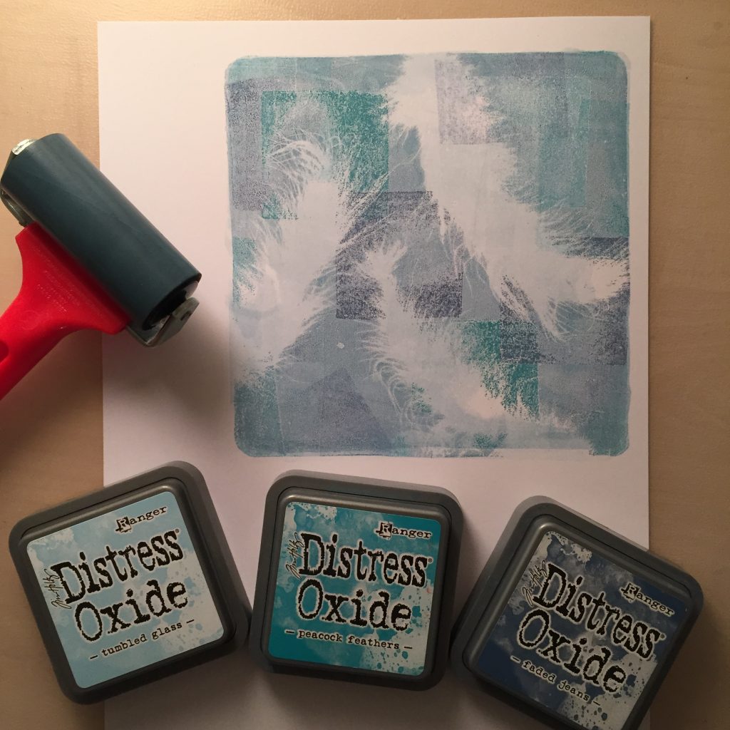 Erster Abzug eines Gelpressdruckes mit Distress Oxide Farben und Federn zur Maskierung